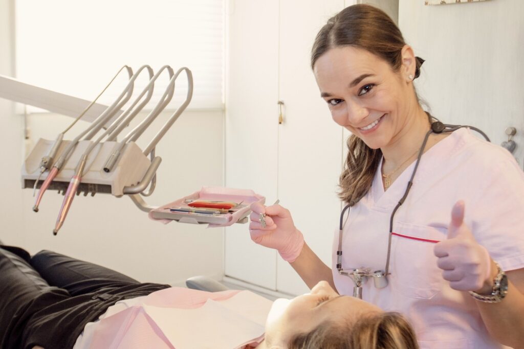 Dra. Ana Cabeza sonriendo junto a una paciente en el sillón dental